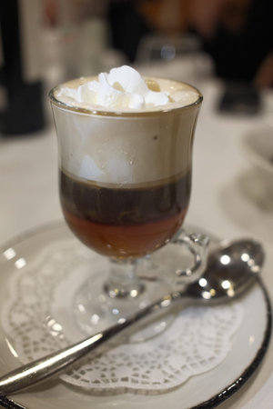 Coffee with whipped cream in a glass on the table.