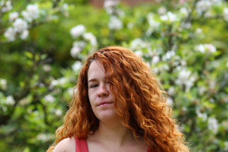 Portrait of a red-haired girl in the spring garden.
