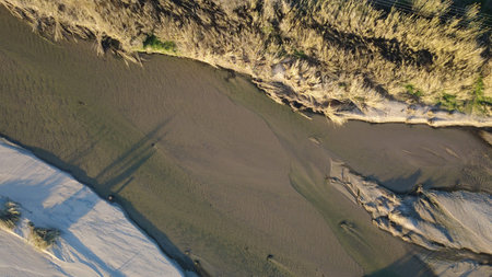 Aerial view of sand dunes at low tide in winter.