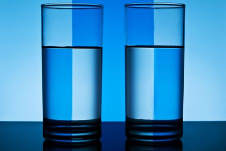 two round glasses of water over abstract backgroundの写真素材