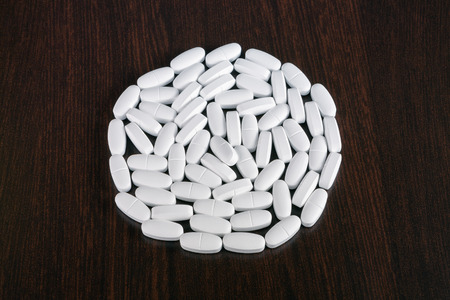 White pills on a wooden tableの写真素材