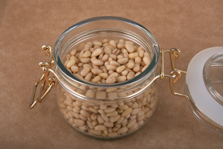 Open glass jar full of cedar nutsの写真素材