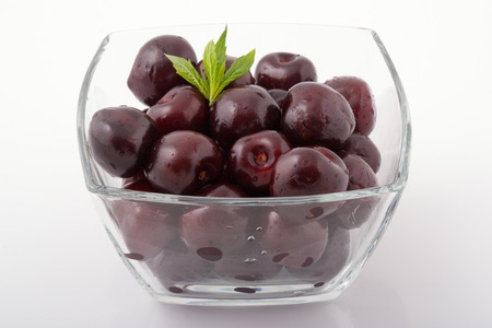 Sweet fresh cherries in a glass bowl, isolatedの写真素材
