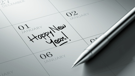 Closeup of a personal agenda setting an important date written with pen. The words Happy New Year written on a white notebook to remind you an important appointment.の写真素材