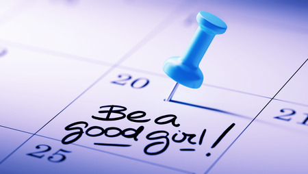 Concept image of a Calendar with a blue push pin. Closeup shot of a thumbtack attached. The words Be a good girl written on a white notebook to remind you an important appointment.の写真素材