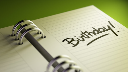 Closeup of a personal agenda setting an important date representing a time schedule. The words Birthday written on a white notebook to remind you an important appointment.の写真素材