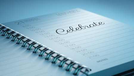 Closeup of a personal calendar setting an important date representing a time schedule. The words Celebrate written on a white notebook to remind you an important appointment.の写真素材