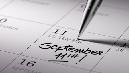 Closeup of a personal agenda setting an important date written with pen. The words September 11th written on a white notebook to remind you an important appointment.の写真素材