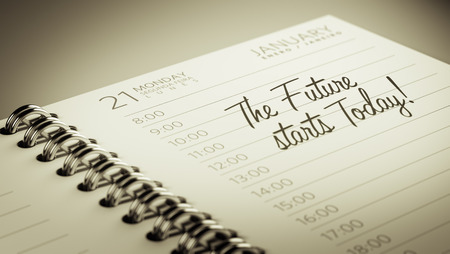 Closeup of a personal calendar setting an important date representing a time schedule. The words The future starts today written on a white notebook to remind you an important appointment.の写真素材