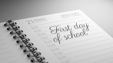Closeup of a personal calendar setting an important date representing a time schedule. The words First day of school written on a white notebook to remind you an important appointment.の写真素材