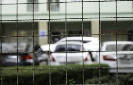 Blurred image of car parking inside fence