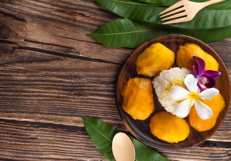 mango sticky rice is  thai dessert dish,most of foreigner like to order when they come to thailand. for this menu serve on the wooden plate in top view.の写真素材