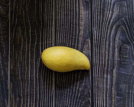 nam-doc-mai is the name of mango  in thailand ,most of thai chef bring them to cook dessert menu like mango with sticky rice,tasty sweet and sour when it's ripe. from top view on wooden backgroundの写真素材