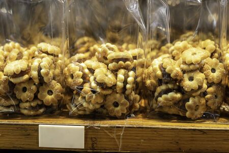 pineapple cookies in plastic packaging put to sell on shelf in bakery shopの写真素材