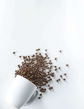 cup with coffee beans fall down isolated on white backgroundの写真素材