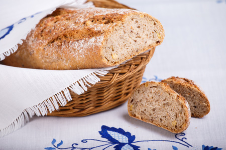 Fresh cereal baguette on white cloth. Sliced bread.