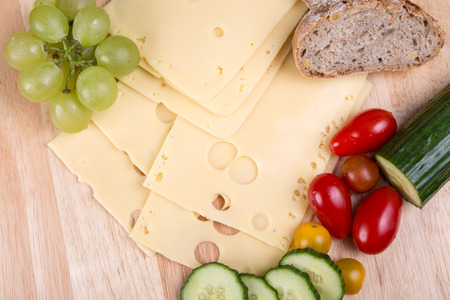 Sliced cheese and vegetable on a cutting board