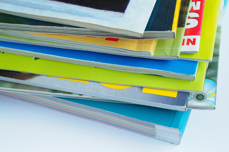 Magazines with selective focus on foreground edge. Edge stack of the colorful magazines