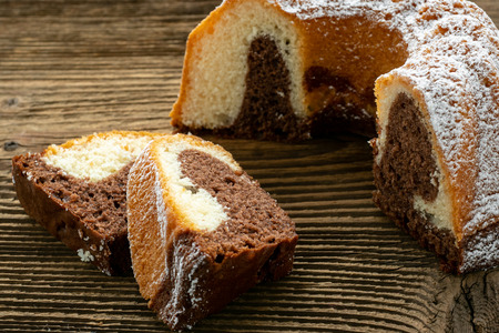 Traditional homemade marble cake. Sliced marble bundt cake on wooden tableの写真素材