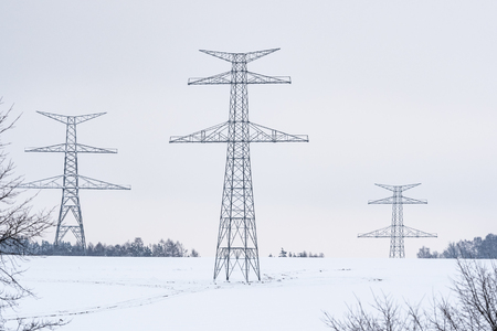 Construction of high voltage pylons in winter. Assembled power transmission line supports, ready for installation.の写真素材