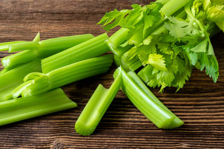 Cut celery sticks and leaves on wooden tableの写真素材