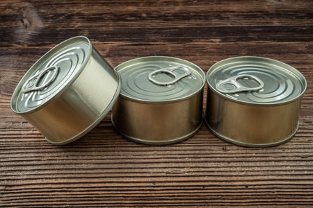Tin cans with food on a wooden tableの写真素材