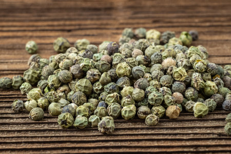 Dried spices green pepper. Peppercorn on a wooden board.の写真素材