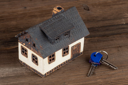Model house and keys on table. Concept of dream houseの写真素材
