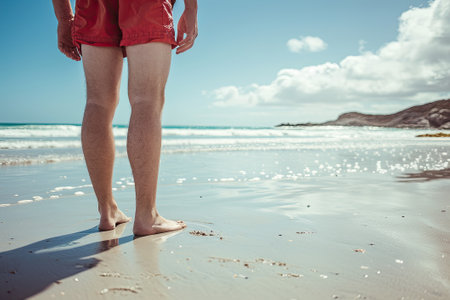 Man in swimming shorts on the beachの素材
