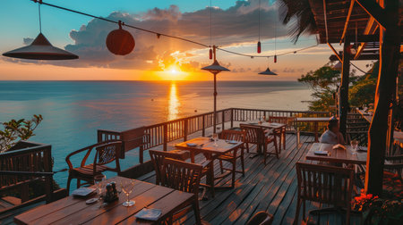 Elegant seaside dining table setup with vibrant sunset in the background.の素材