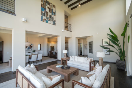 Spacious open plan living room featuring high ceiling, wooden beams, and stylish furniture, creating a luxurious and comfortable atmosphereの素材