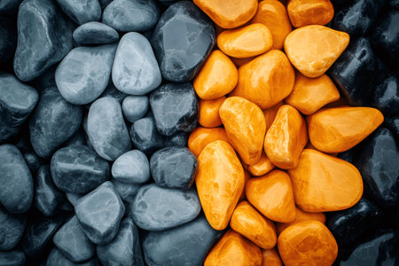 Gray and orange polished stones are creating a natural division, perfect for backgrounds and texturesの素材
