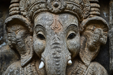 Close-up of a weathered stone statue of Ganesha, showcasing intricate details and conveying spiritual significanceの素材