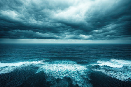 Dark storm clouds are gathering over a wild ocean with big waves, creating a dramatic and powerful sceneの素材