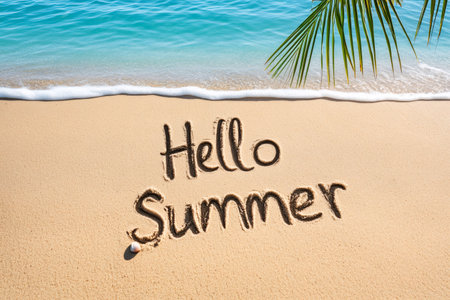 Hello summer written in the sand on a tropical beach with turquoise water and palm tree leafの素材