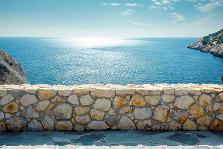 Scenic view of the Mediterranean sea sparkling under the sun, seen from a stone wall viewpointの素材