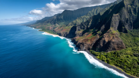 Aerial view of the rugged na pali coast on Kauai Island, Hawaii, showcasing dramatic cliffs, pristine turquoise waters, and a touch of cloudsの素材