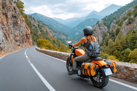 Woman riding motorcycle on a scenic mountain road during a summer adventureの素材