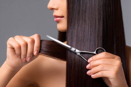 Close up of a hairdresser cutting long, straight hair with professional scissors, demonstrating a hairdressing techniqueの素材