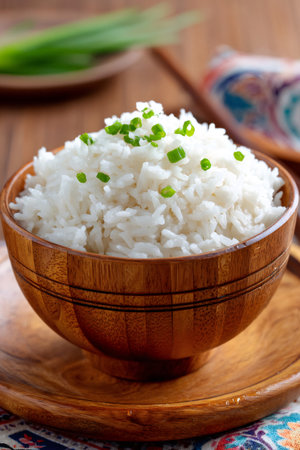 Perfectly cooked rice seasoned with chopped green onions, served in a traditional wooden bowl, representing a healthy and delicious mealの素材