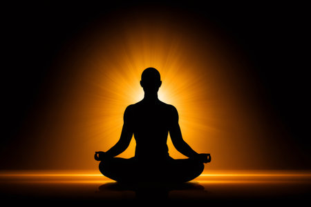 Silhouette of meditating man in lotus position with glowing auraの素材