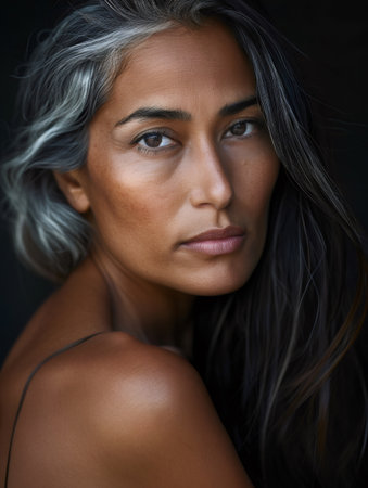 Woman with dark skin and graying hair looking directly at the viewerの素材