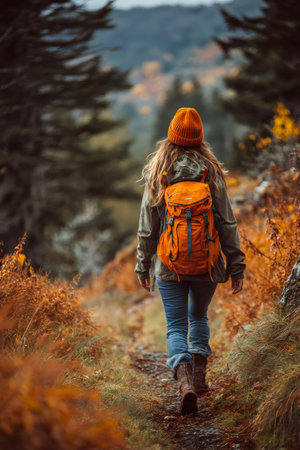 Woman backpacking along a rustic path in a vibrant autumn forestの素材