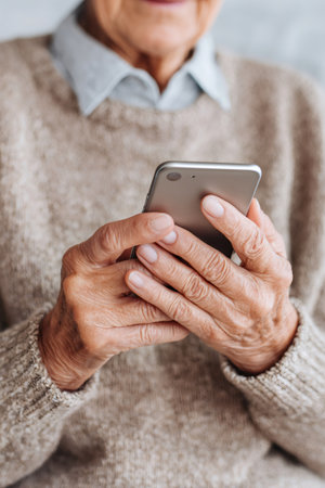 Senior woman using a modern smartphone, embracing digital communicationの素材
