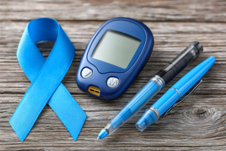 Blue ribbon, blood glucose meter, and insulin delivery pen on wooden surface for diabetesの素材
