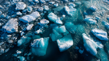 Glacier melting creating icebergs floating in cold blue ocean waterの素材