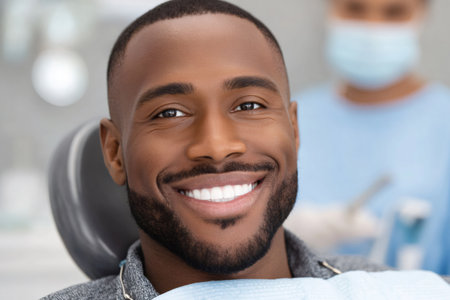 African American man having a wide cheerful smile, sitting in a dentist's chairの素材