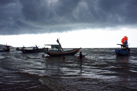 At evening, boats went back to the seaside after workday begin at 2am  At this time, the weather very bad, in storm stage, dark clouds moved towards  Took at Ba Ria, Viet Nam- July 15, 2013のeditorial素材