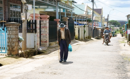 DA LAT, VIET NAM- SEPTEMBER 5: The white beard old man with stick in hand walking on the street in Dalat, Viet Nam on September 5, 2013          のeditorial素材