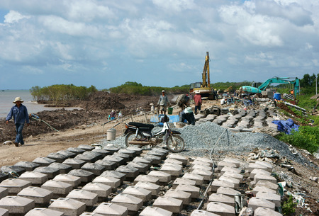 MEKONG DELTA, VIETNAM- JULY 8  Asia worker working at  breakwater construction site, bulldozer,...